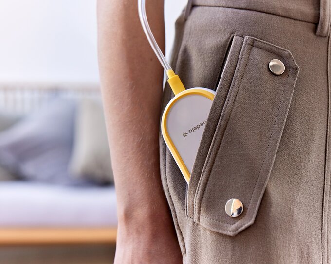 Medela Freestyle™ Hands-free double electric wearable breast pump tucked into mom's pocket
