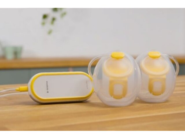 Medela Freestyle™ Hands-free double electric wearable breast pump and collection cups sitting on counter