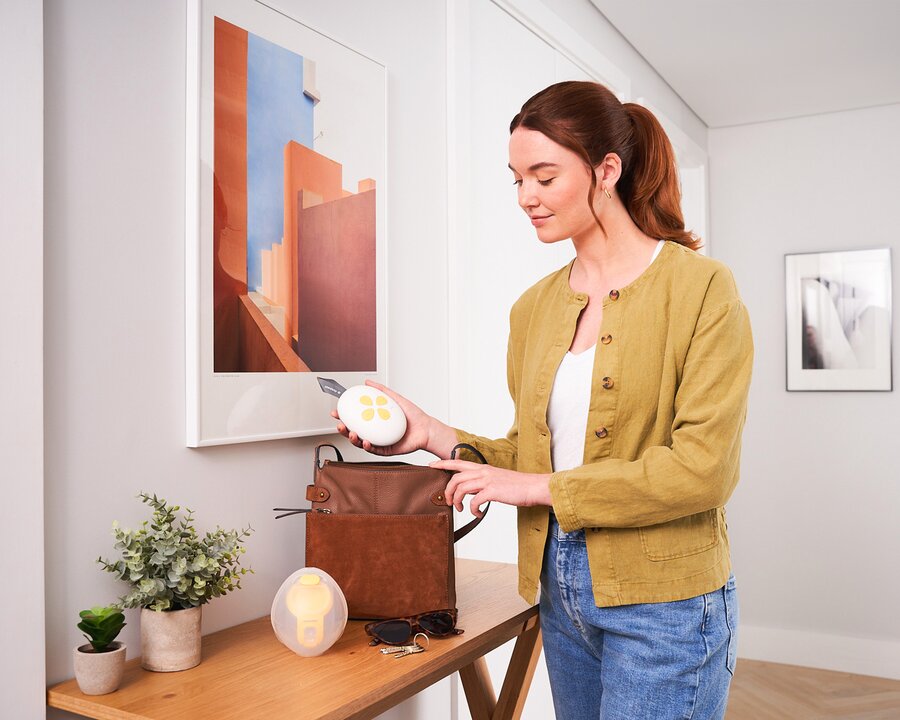 Solo™ Hands-free single electric breast pumps | © Solo™ Hands-free single electric breast pumps Mama stopt de Medela Solo™ Hands-free enkele elektrische borstkolf in haar tas | © Solo™ Hands-free single electric breast pumps