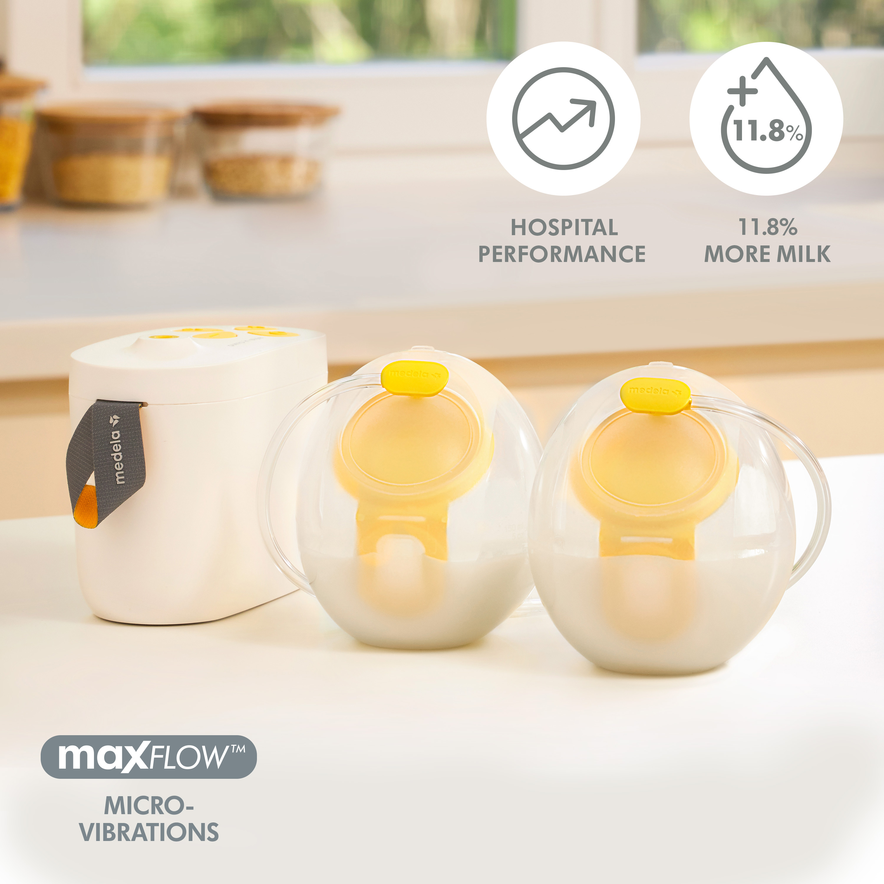 Medela Pump In Style® Hands-free double electric breast pump with Hands-free collection cups filled with milk sitting on counter.  Text on image, "Hospital performance, 11.8% more milk, MaxFlow Micro-Vibrations"