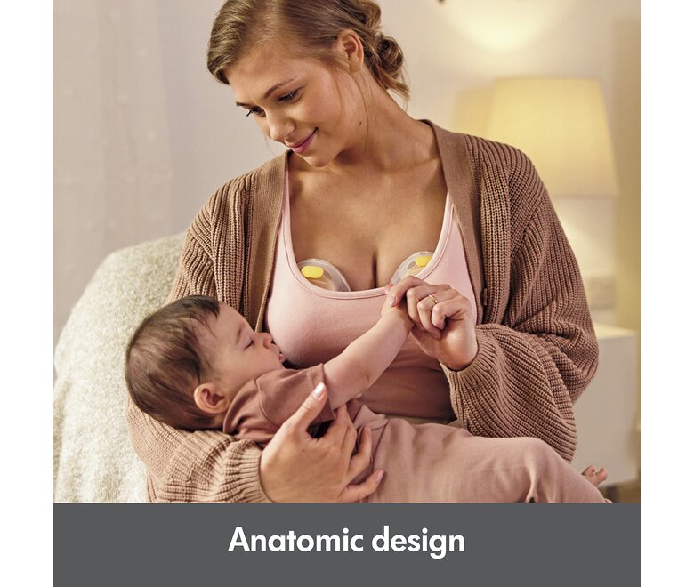 Woman holding baby while pumping with the Medela Swing Maxi™ double electric breast pump.  Text at bottom of image says, "Anatomic design"