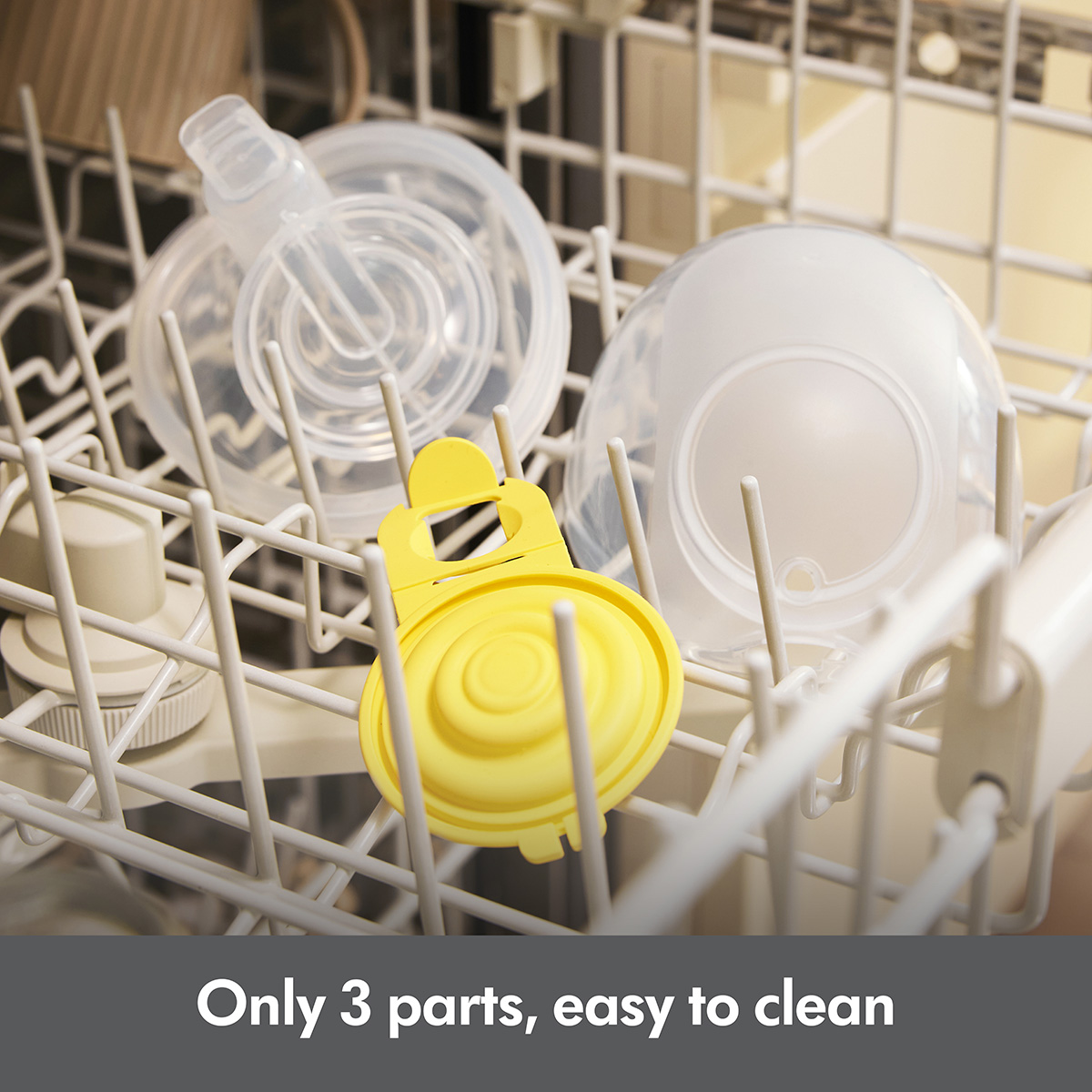 A Medela Hands-free Collection Cup in three parts placed on top rack of the dishwasher.  The text reads: “Only 3 parts, easy to clean”.