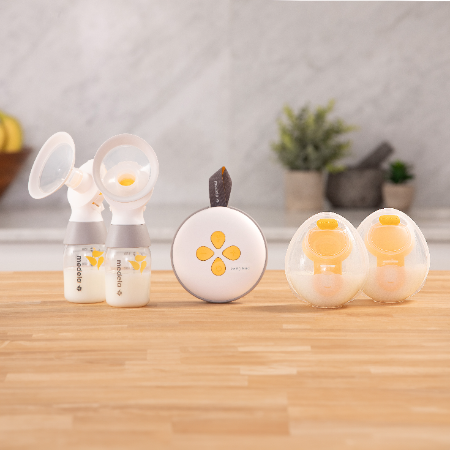 Medela Swing Maxi™ dubbele elektrische borstkolf op toonbankmodel met twee Classic opvangbekers en twee Hands-free opvangbekers.
