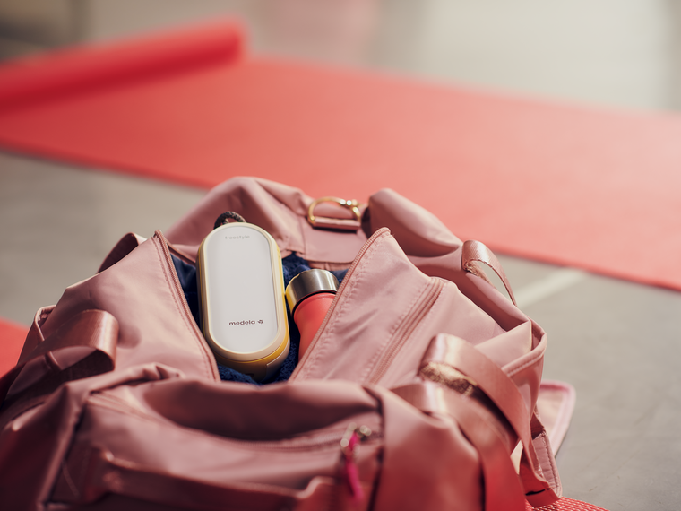 Medela Freestyle Flex™ Two-phase double electric breast pump sitting in the top of a mom's purse