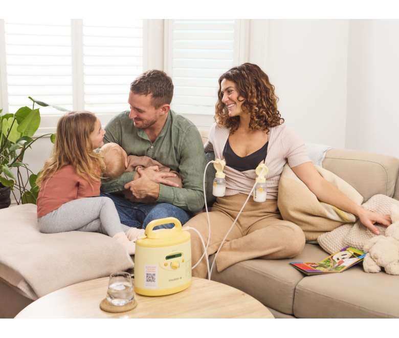 Eine Mutter pumpt zu Hause mit einer gemieteten Medela Symphony® Milchpumpe ab, während sie Zeit mit ihrer Familie verbringt.