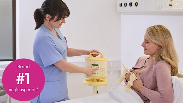 Un'infermiera mostra a una mamma come usare il tiralatte Medela Symphony PLUS® noleggiato. Testo dell'immagine: “Brand #1 negli ospedali".