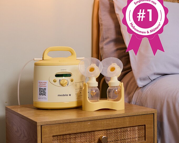 Eine Medela Symphony® Milchpumpe auf einem Nachttisch. Text mit rosa Aufschrift: „#1 Empfohlen von Hebammen und Müttern".