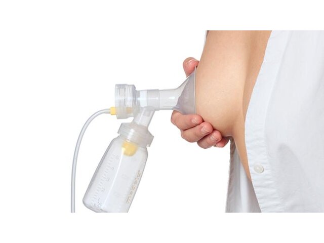 A mother demonstrates where the breast shield should be placed when pumping.