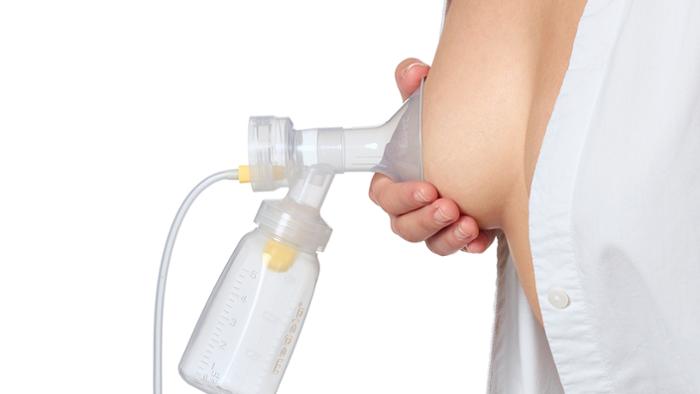 A mother demonstrates where the breast shield should be placed when pumping.