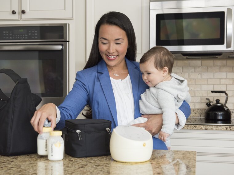Working Mom packing up her Medela Sonata® breast pump and Cooler Bag with filled breast milk storage bottles