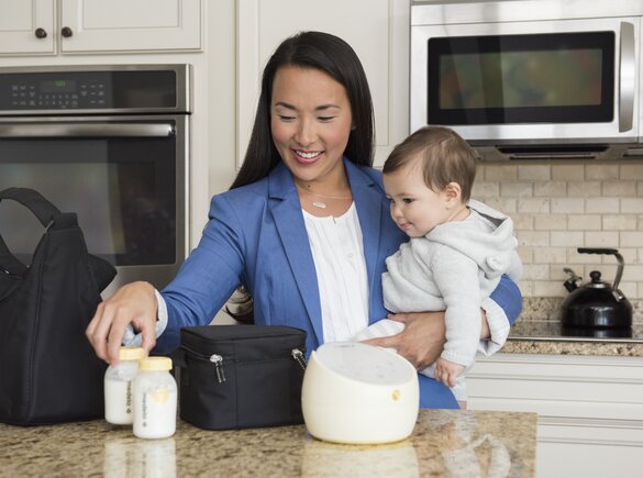 Working Mom packing up her Medela Sonata® breast pump and Cooler Bag with filled breast milk storage bottles