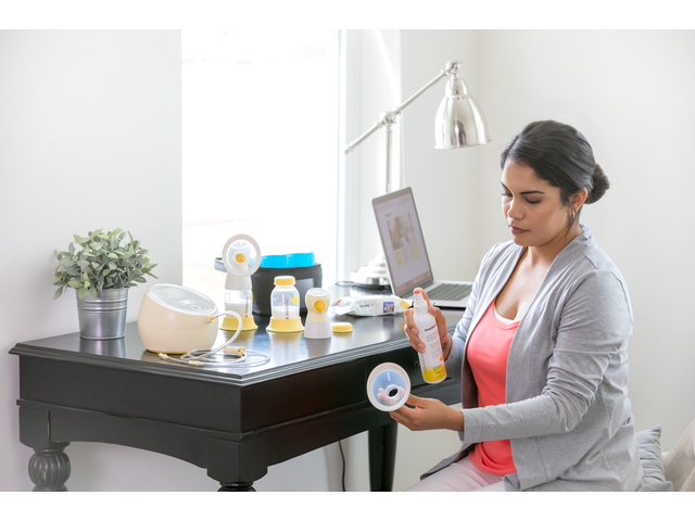 A Mom disinfects her breast pump and accessories with the Medela Quick Clean™ Breast Pump & Accessory Sanitizer Spray after pumping at work 