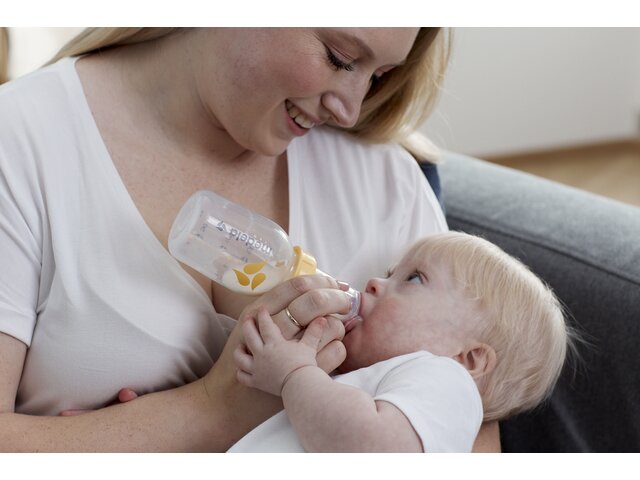 A baby is fed by its Mom using a Medela SpecialNeeds™ Feeder system.
