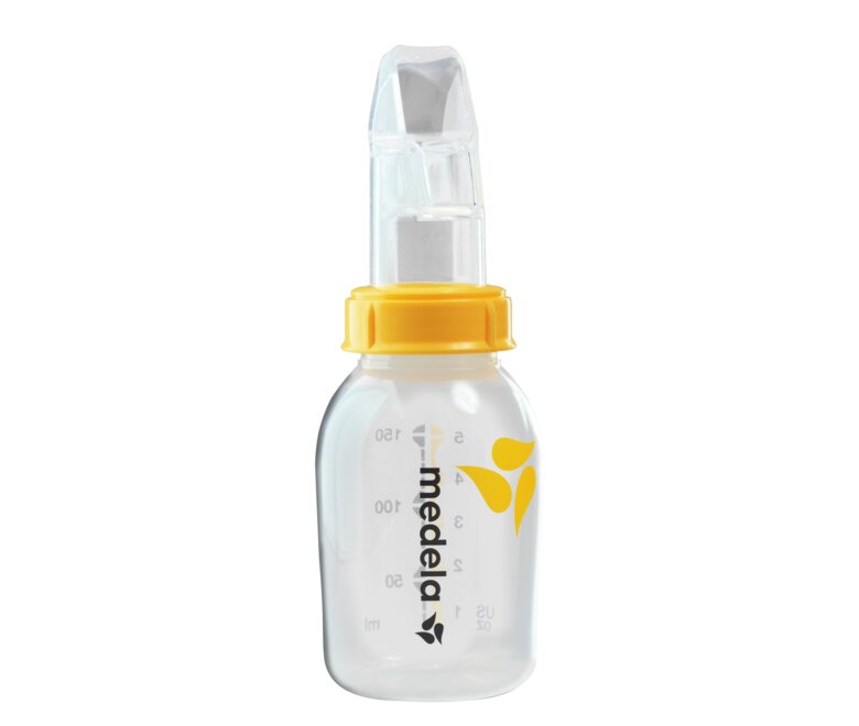 An advanced cup feeder, the Medela SoftCup™. It is connected to a reusable Medela breast milk storage bottle.