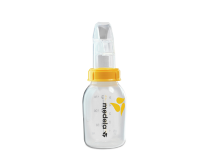 An advanced cup feeder, the Medela SoftCup™. It is connected to a reusable Medela breast milk storage bottle.