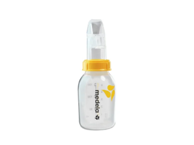 Un distributeur de tasses perfectionné, le Medela SoftCup™. Il est relié à un biberon réutilisable de stockage du lait maternel Medela.