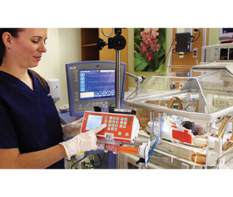 A nurse working with the Medela Enteral Feeding Pump in a hospital neonatal ward.