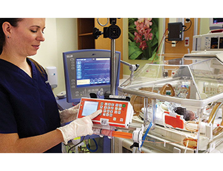 A nurse working with the Medela Enteral Feeding Pump in a hospital neonatal ward.