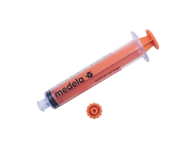 ENFit Syringe with plunger pushed down and cap sitting to the side.