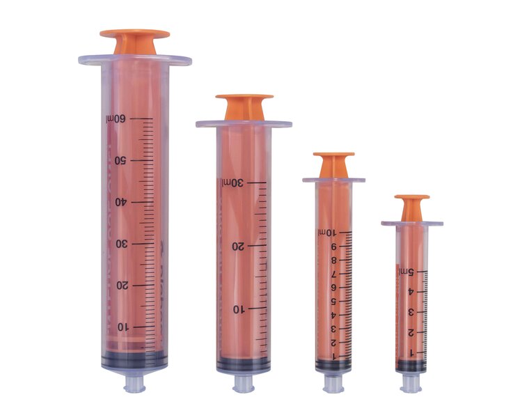 ENFit Syringe Various sizes of ENFit Syringes from 5 mL to 60 mL, all with plungers pushed in and caps removed.