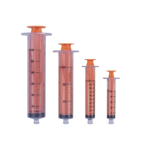 Various sizes of ENFit Syringes from 5 mL to 60 mL, all with plungers pushed in and caps removed.