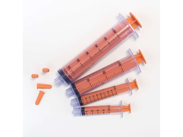 Various sizes of TwistLok syringers with plungers down and caps off.