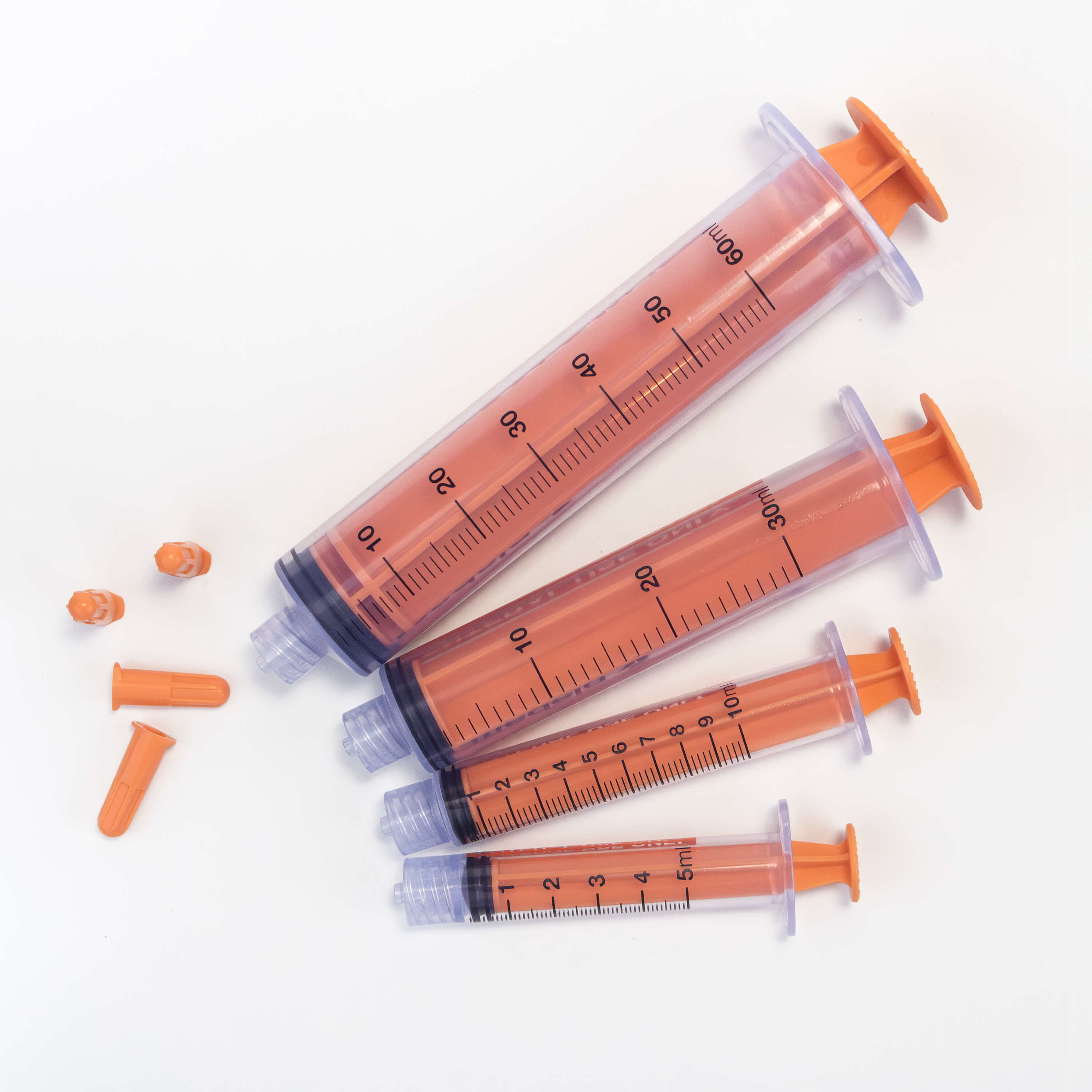 Various sizes of TwistLok syringers with plungers down and caps off.