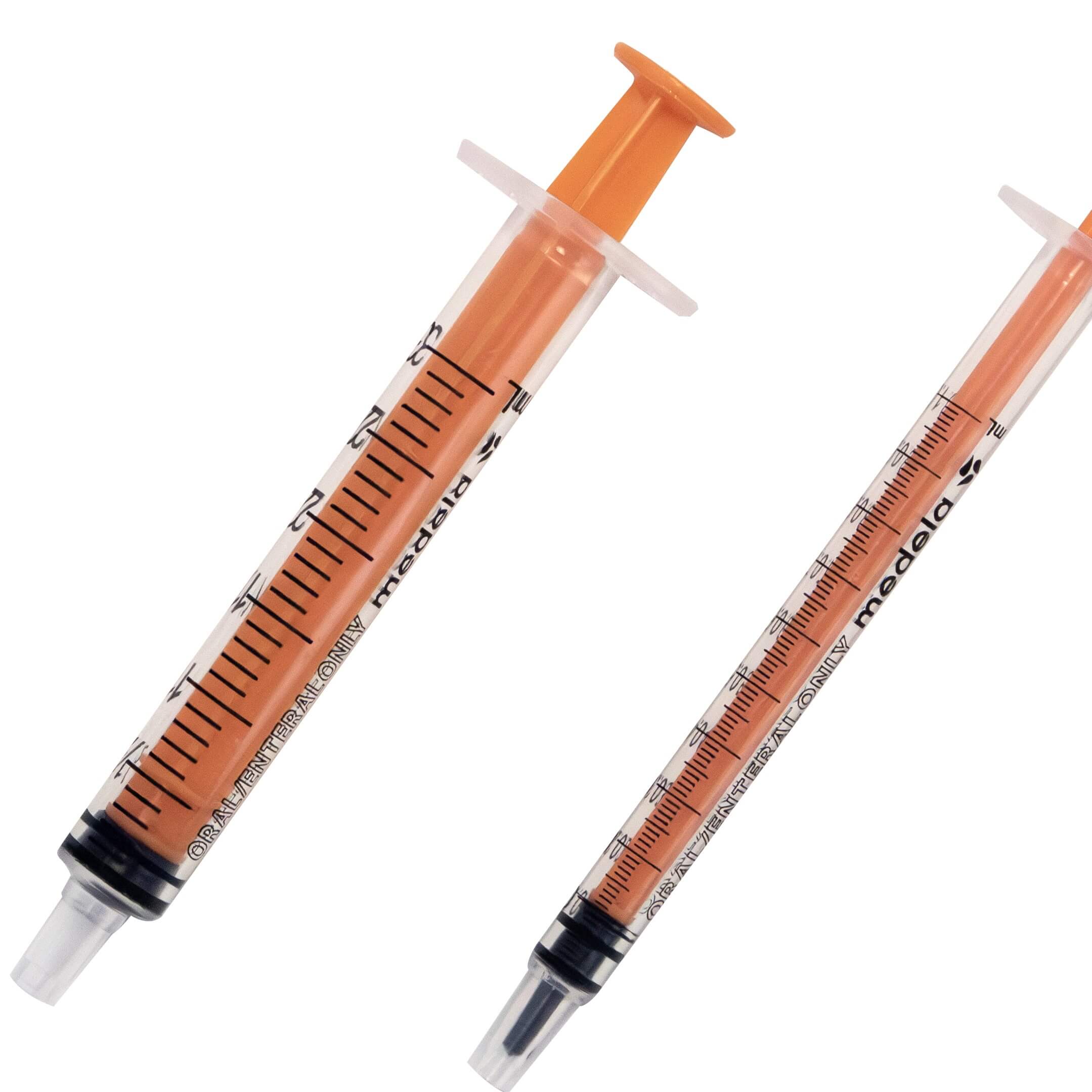 Close up of two sizes of slip tip oral syringes showing gradient markings.