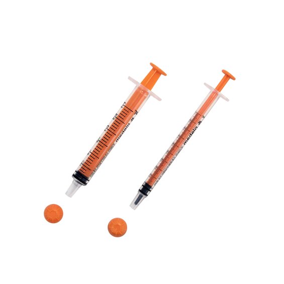 Two sizes of oral slip tip syringes with caps removed.