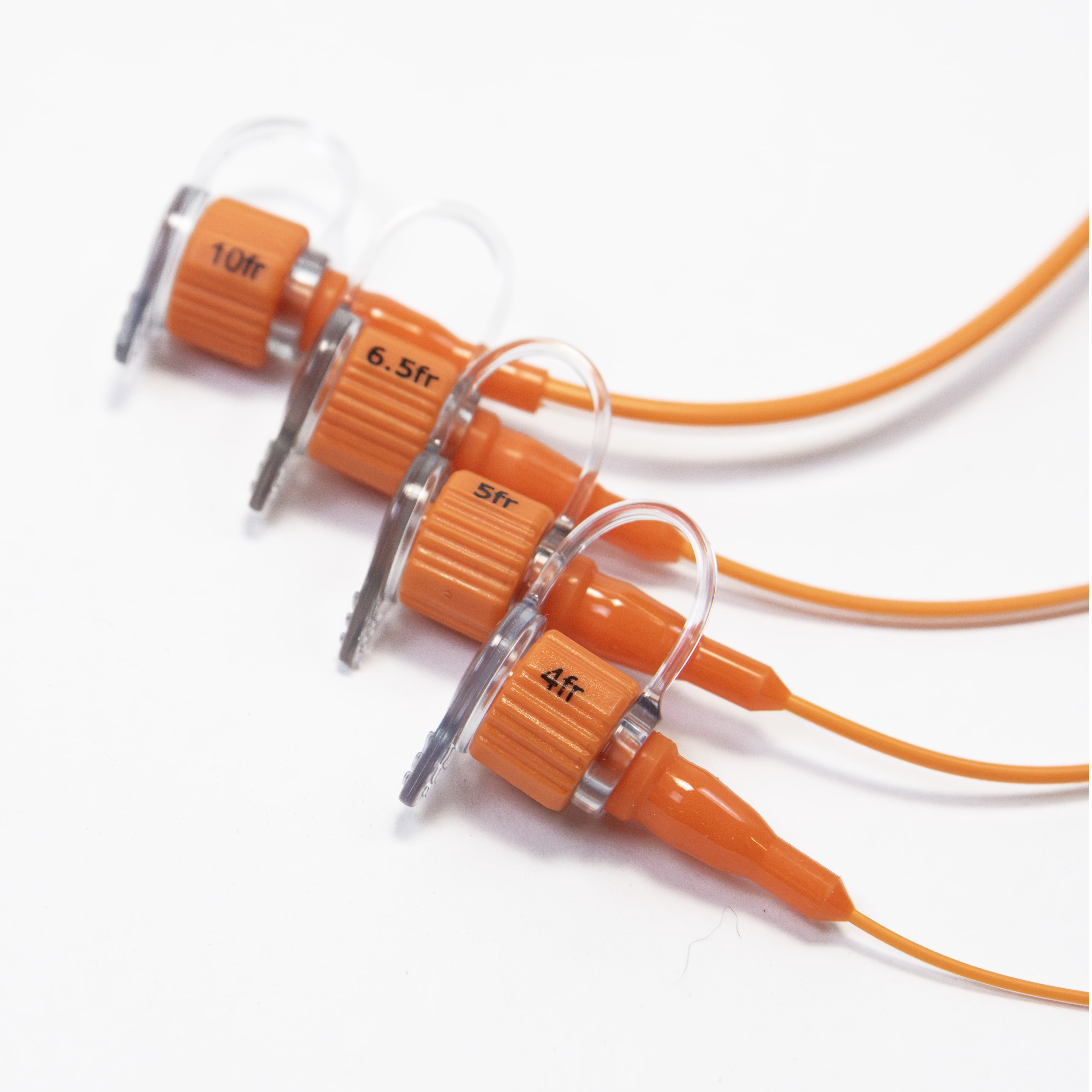 Close up of four sizes of ENFit polyurethane feeding tube.  Sizes are 10fr, 6.5fr, 5fr, and 4fr.