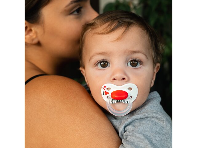 A baby uses a Medela Original dummy while being comforted by the mom.
