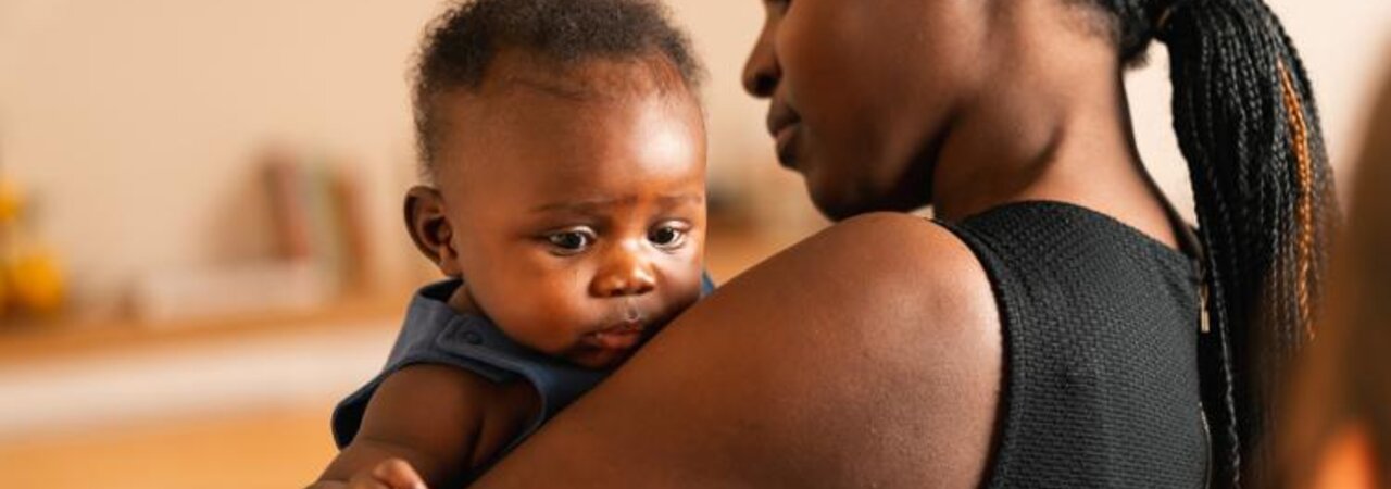 Eine Mutter hält ihr Baby zu Hause im Arm.