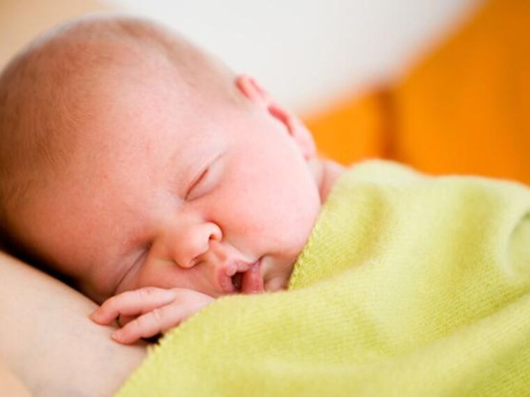 A newborn lies skin-to-skin on its mother.