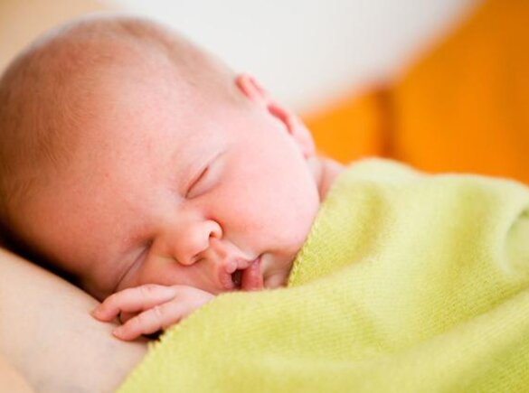 A newborn lies skin-to-skin on its mother.