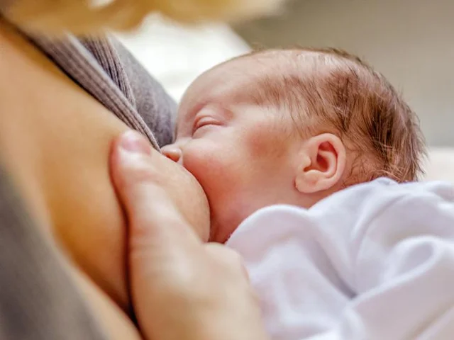 Close-up of a mom breastfeeding her newborn baby.