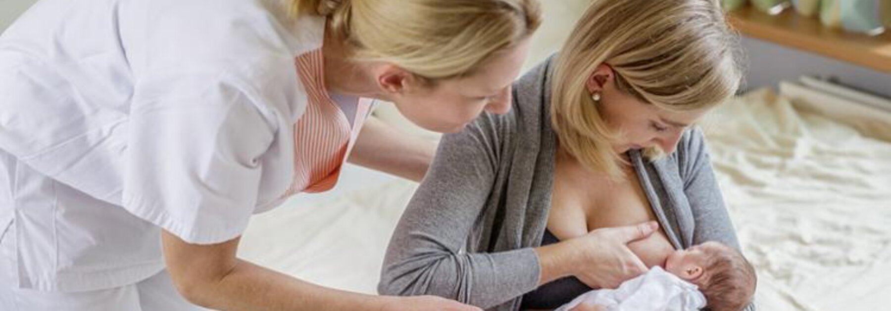 A lactation consultant teaches a mom techniques for breastfeeding.