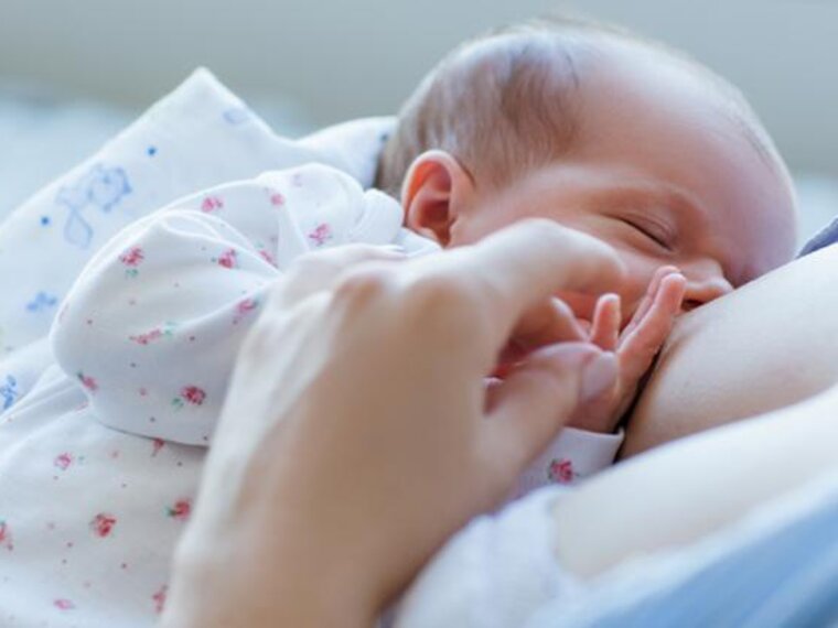 Een moeder die haar baby borstvoeding geeft tijdens de eerste maand.
