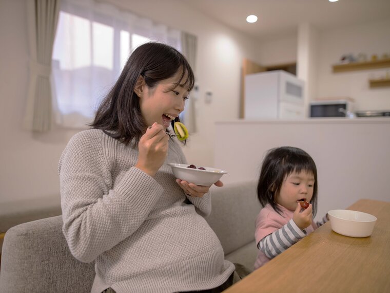 Pregnant woman enjoying a healthy meal, emphasizing the importance of nutrition during pregnancy.