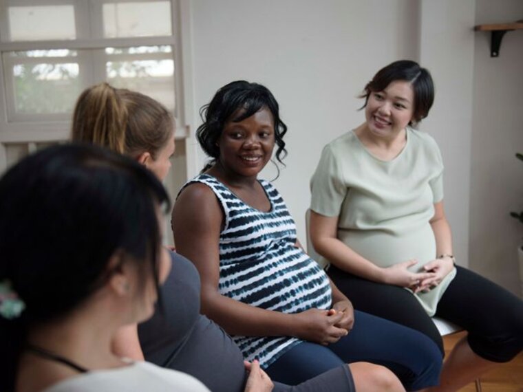 Pregnant women talk together in a group.