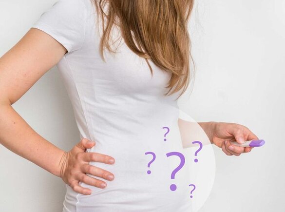 Eine Frau hält einen Schwangerschaftstest in der Hand.