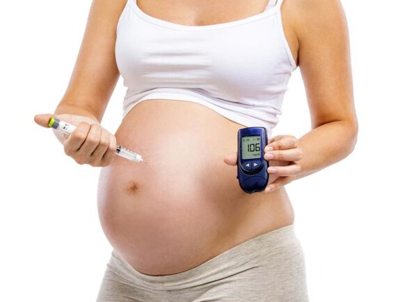 Schwangere Frau mit Schwangerschaftsdiabetes mit Blutzuckerset und Spritze.