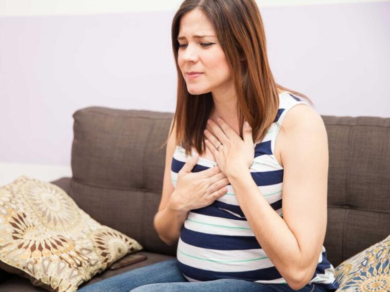 Eine schwangere Frau leidet unter Sodbrennen.