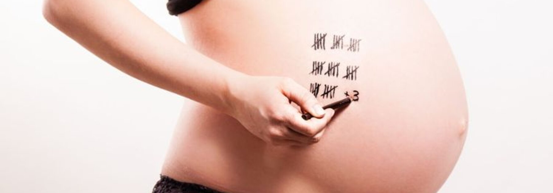 Eine schwangere Frau zählt die Wochen bis zur Entbindung.