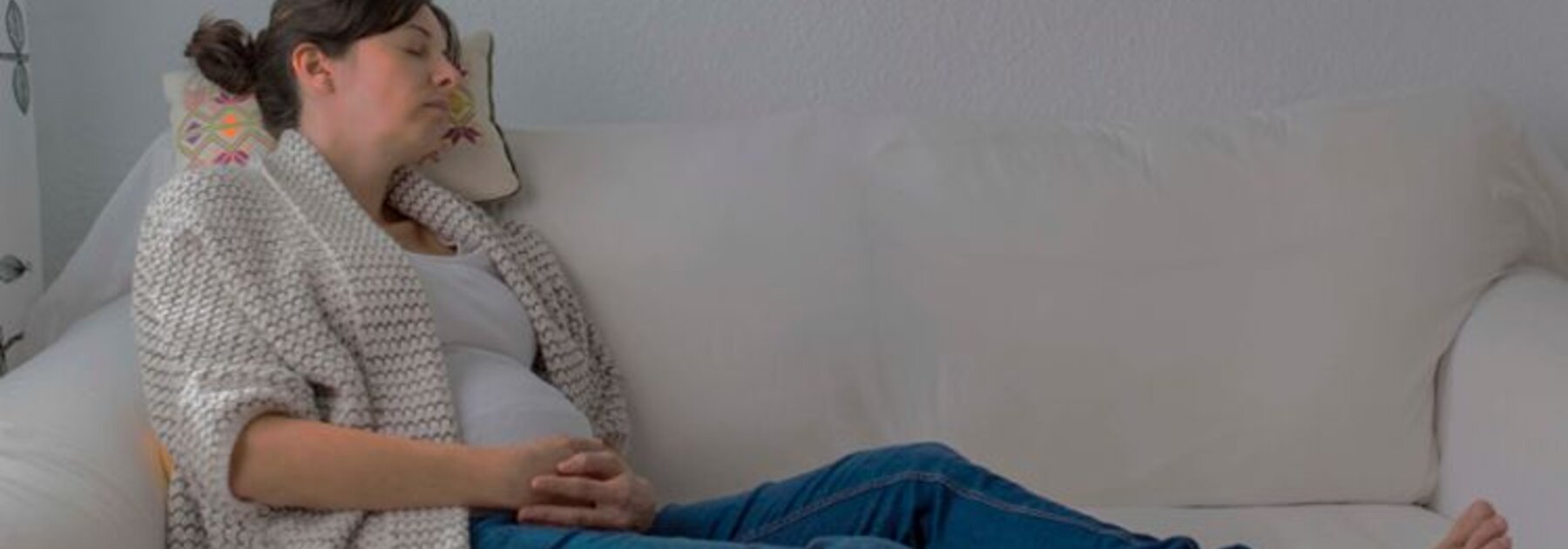 Zwangere moeder dut op een bank.