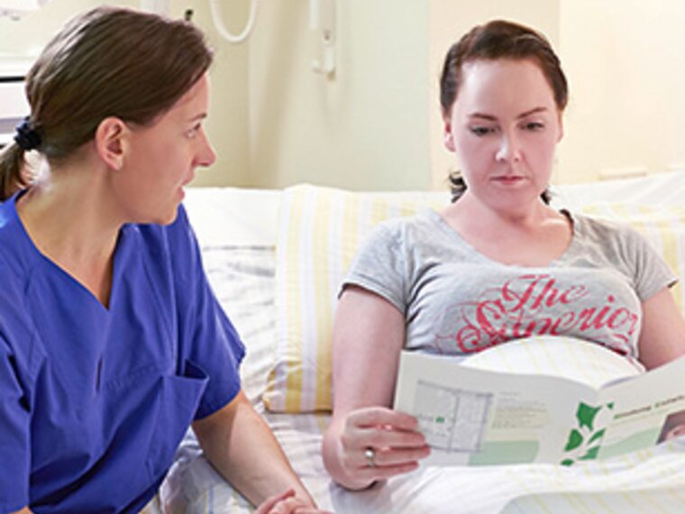 Eine Krankenschwester gibt einer Mutter Informationen über Mastitis.