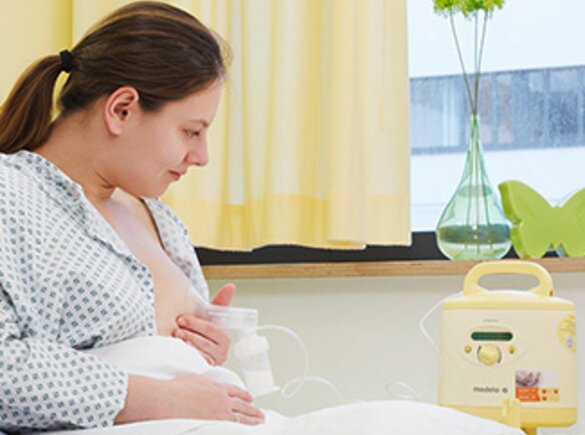 Eine Mutter verwendet die Medela Symphony® Milchpumpe, um ihre physiologische Brustverstopfung zu behandeln.