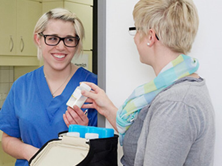 Zwei Frauen in einem Krankenhaus mit Muttermilch in Vorratsflaschen in einer Medela Kühltasche.