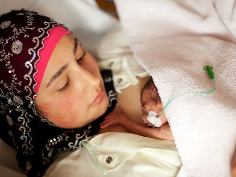 A premature baby has skin-to-skin contact with its mother.