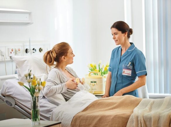 Uma mãe recebe conselhos de uma enfermeira no hospital sobre a utilização da bomba tira leite Symphony®.