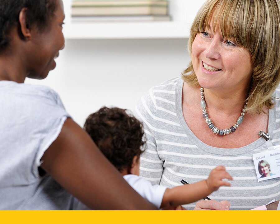 Woman holding a baby and talking with a lactation professional